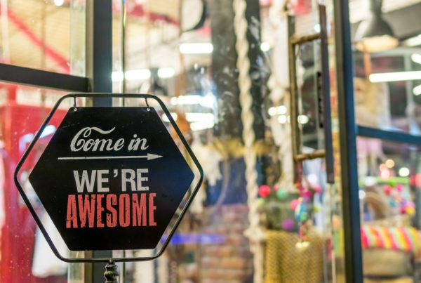 Storefront window with a sign that says "Come in. We're awesome."