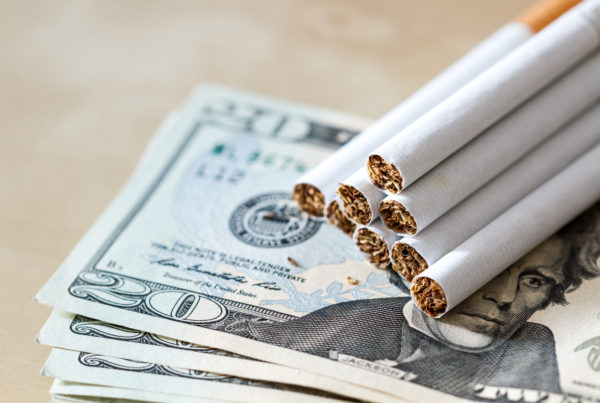 Cigarettes stack on cash symbolizing tobacco scan data program