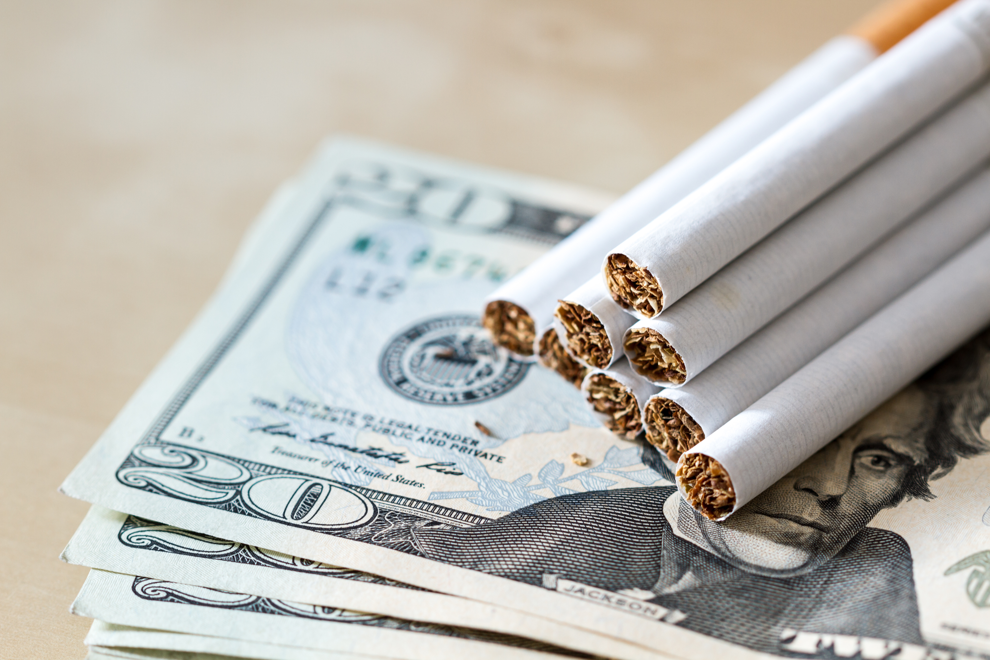 Cigarettes stack on cash symbolizing tobacco scan data program