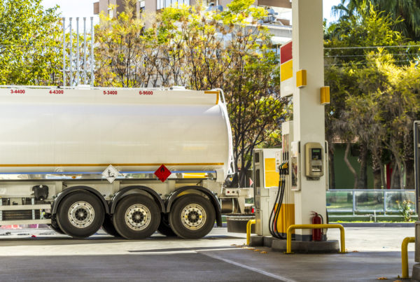 Fuel truck delivering gas at a gas station.