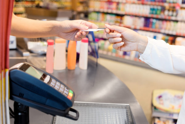 Woman paying with credit card at a convenience store.