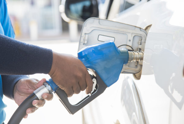 Person filling up car with fuel at a gas station.